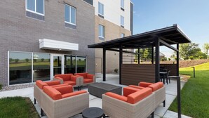 An outdoor patio area with wicker furniture and a pergola. - Candlewood Suites Shelbyville by IHG (Shelbyville)
