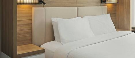 Un dormitorio moderno con cabecera de madera, dos lámparas de noche y una cama bien tendida.
