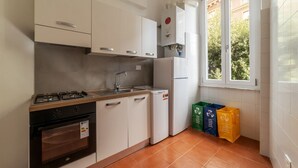 A compact kitchen with white cabinets, a gas stove, a built-in oven, a sink, and a window with a view of greenery. - GuestHost - Accommodation of 90 sqm on the first floor of a building with elevator, about 10 steps to access (NOT suitable for disabled), ideal for 4 guests.Located in a strategic position two passes from the Vatican and the Sala Nervi, just steps from S (Roma)