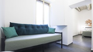 Une chambre moderne avec un canapé, une petite table et un lit.