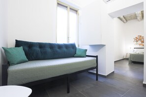 Une chambre moderne avec un canapé, une petite table et un lit.