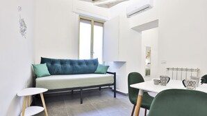 Une pièce moderne comprenant un canapé, une table à manger, des chaises et un radiateur.