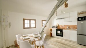 A modern kitchen with white cabinets, a stainless steel refrigerator, and a wooden countertop. - Le Villandry beautiful apartment (Tours)