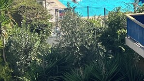 Una piscina con sillas de descanso y una persona nadando.