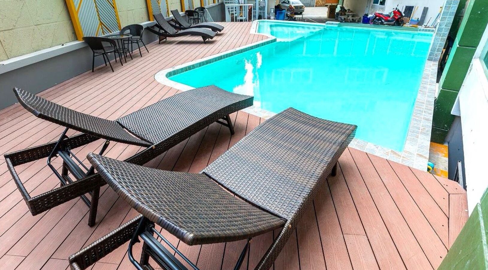 A poolside area with lounge chairs and a pool.