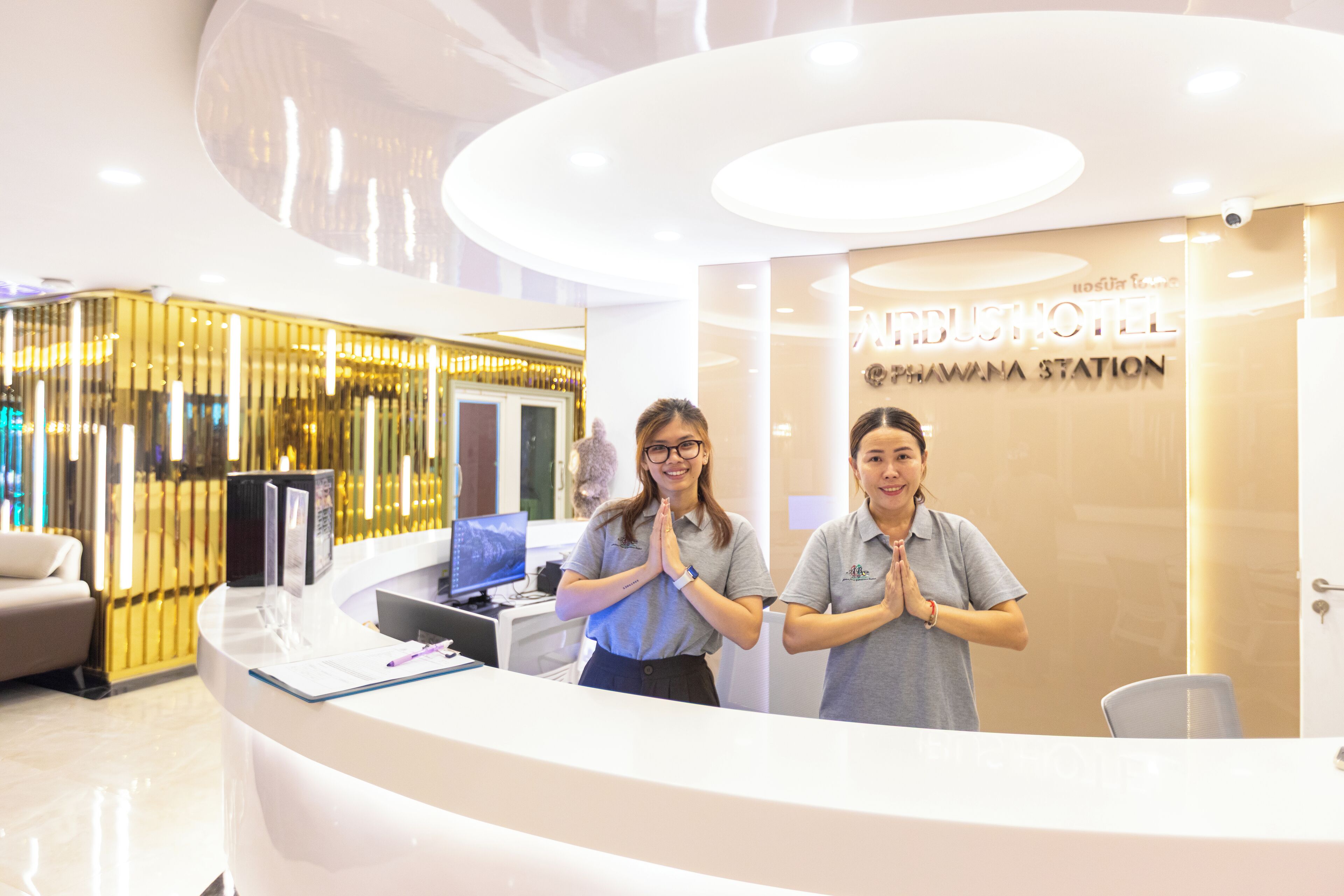 A reception desk at the Nephrangi Hotel with a modern design, a computer, and a seating area.