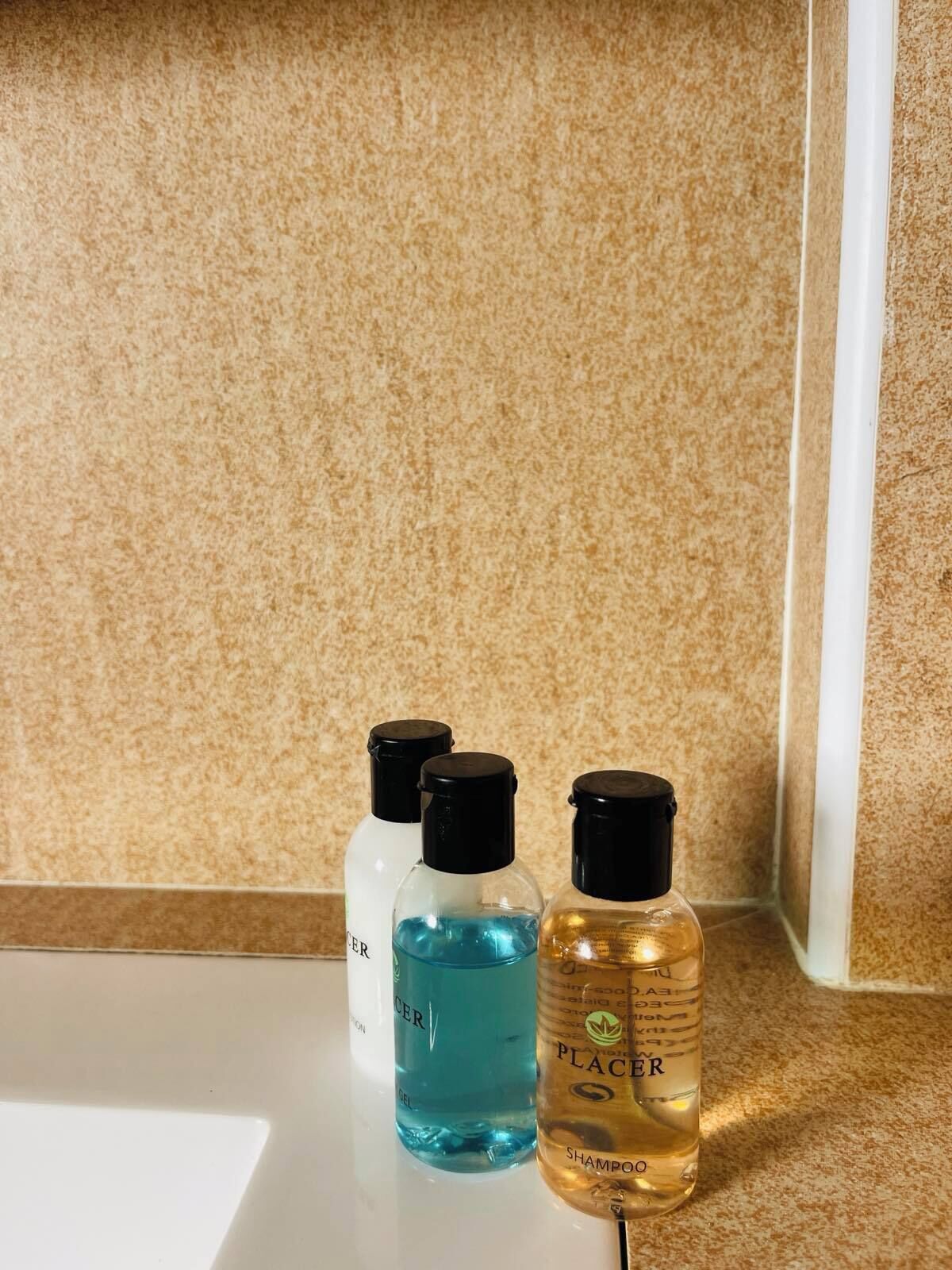 Three bottles of hair care products on a countertop.