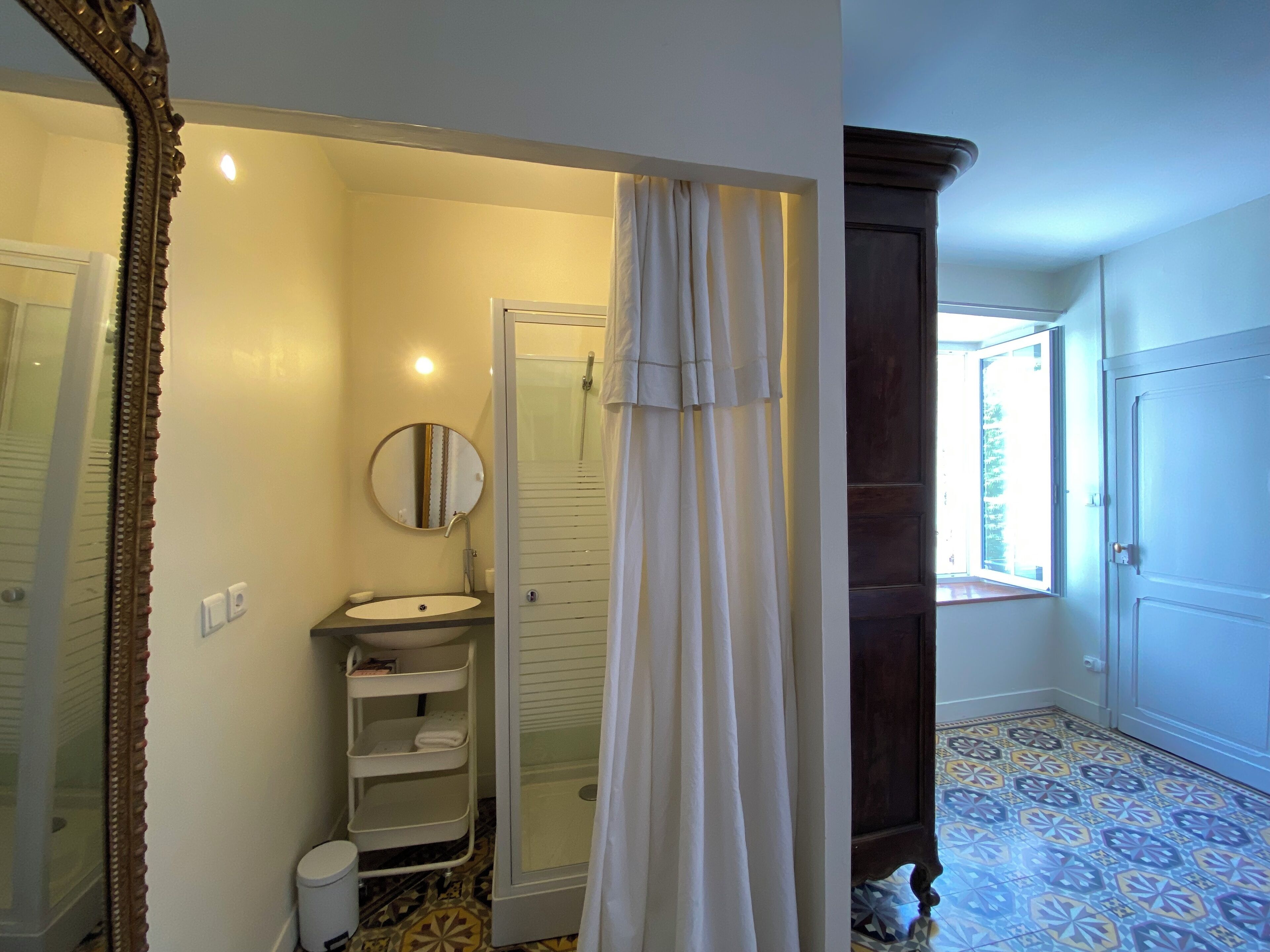 A bathroom with a shower, a sink, and a mirror.