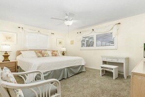 Relax in this serene suite with a large bed, desk, and comfortable seating area.