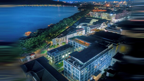 An aerial view of a modern building complex with multiple floors, large windows, and a central courtyard. - Renhe Hotel (Hangzhou)