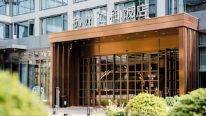 A modern building with large glass windows and a wooden facade. - Renhe Hotel (Hangzhou)