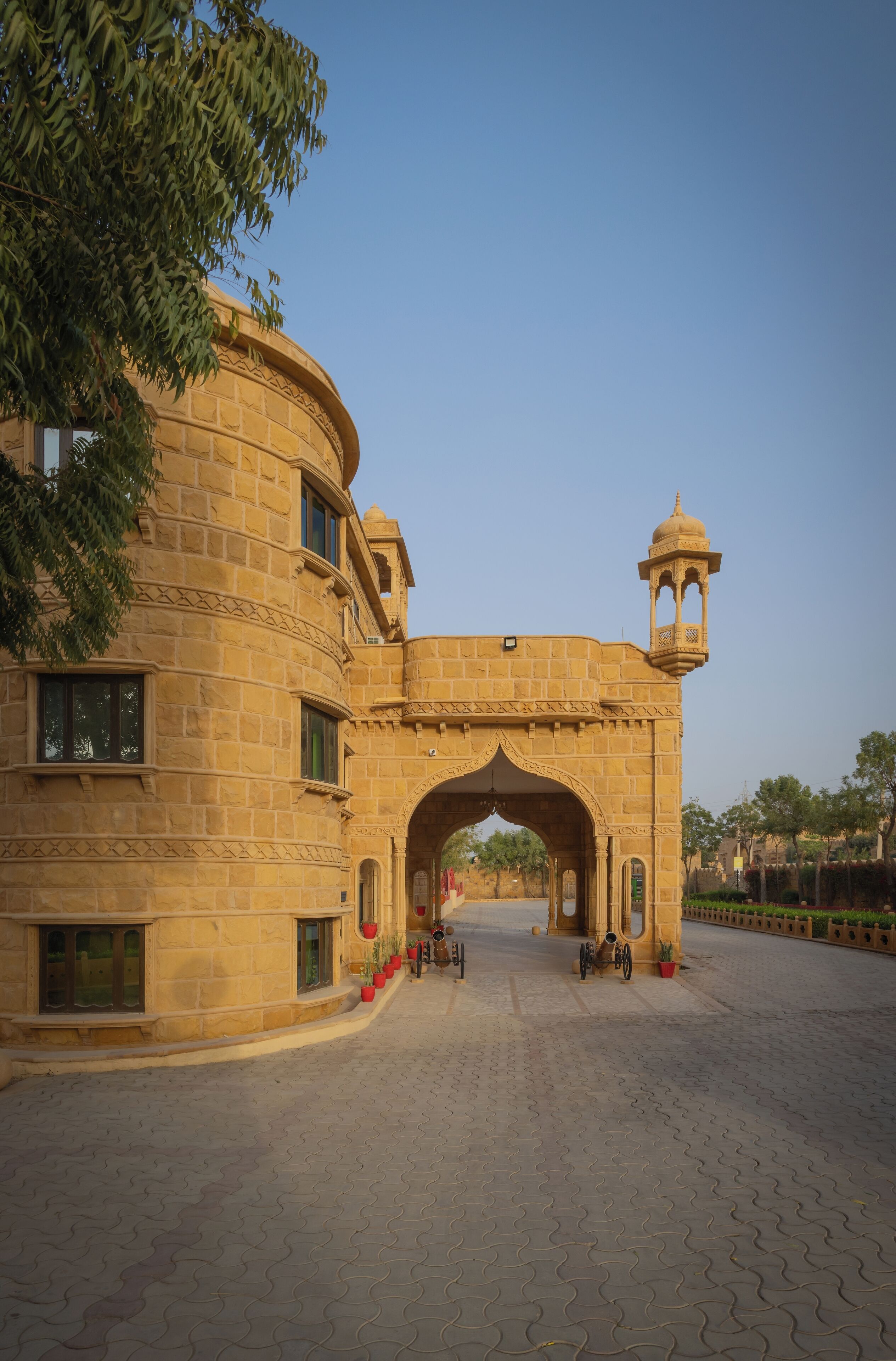 A large, historic building with a prominent archway and a small tower.