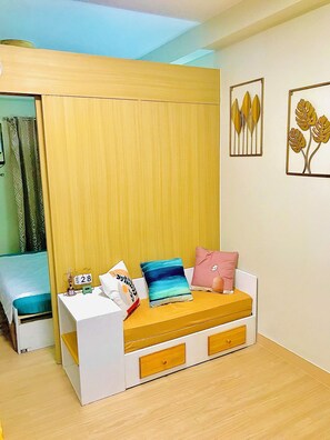 Cozy bedroom with a single bed, bedside table, and framed artworks.