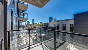 Un edificio moderno con un balcone in vetro che si affaccia su un panorama urbano.
