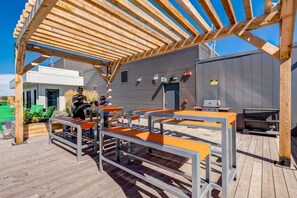 Eine Terrassensitzgruppe mit Holzbänken und einer Pergola.