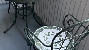 A round table with a mosaic tile design and metal chairs with matching patterns. - Along the airport line, nearest stations Hanazonomachi and Haginochaya 2 min. each [ 305] Japanese-style room with mini-kitchen and private bathroom, excellent access [ 305]. (大阪市)
