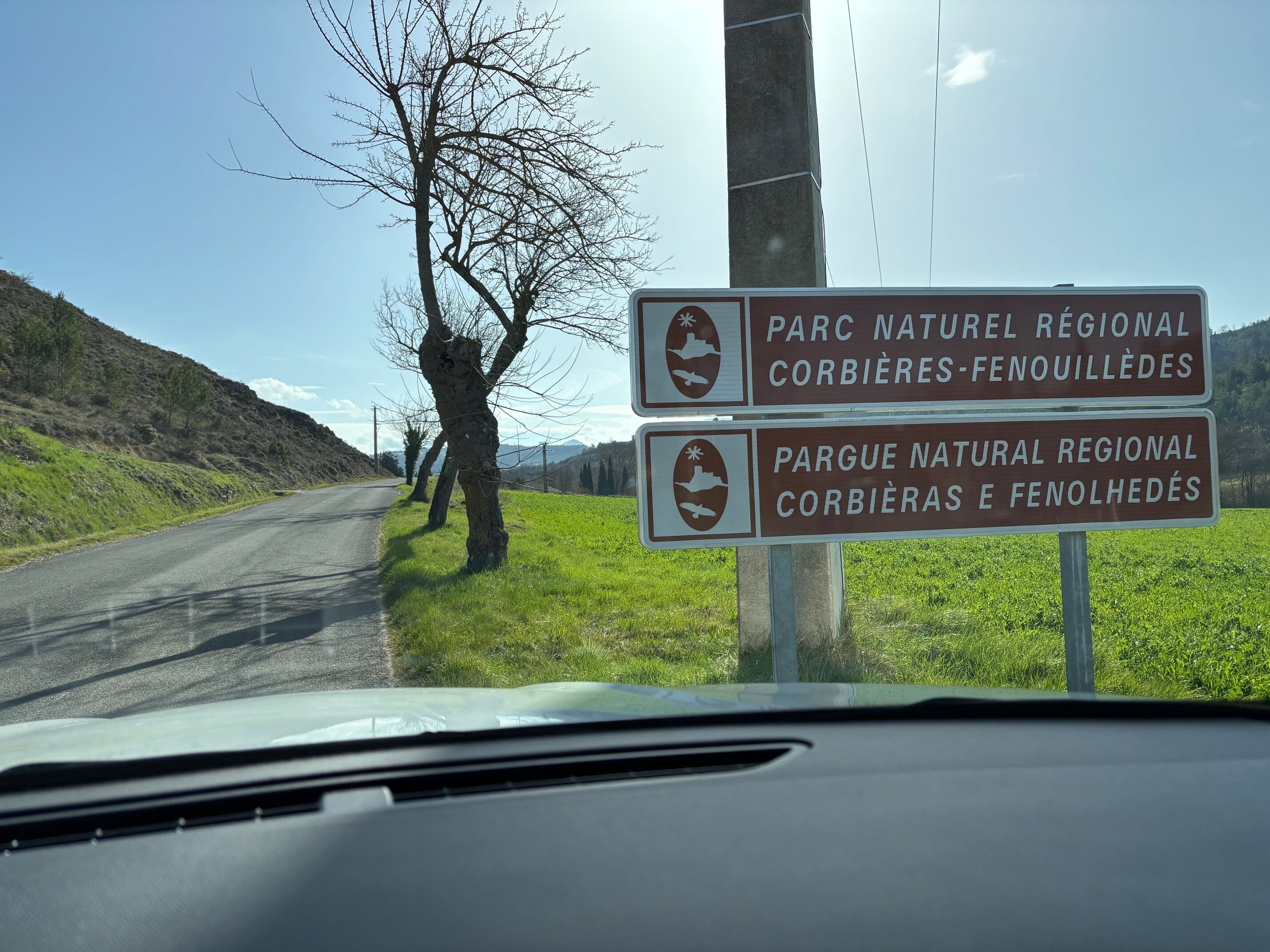 A road sign indicating a regional natural park with a mountainous backdrop.