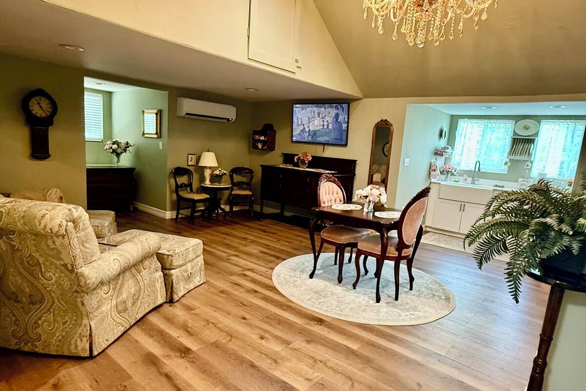 Amplia sala de estar con comedor, televisor y candelabro.