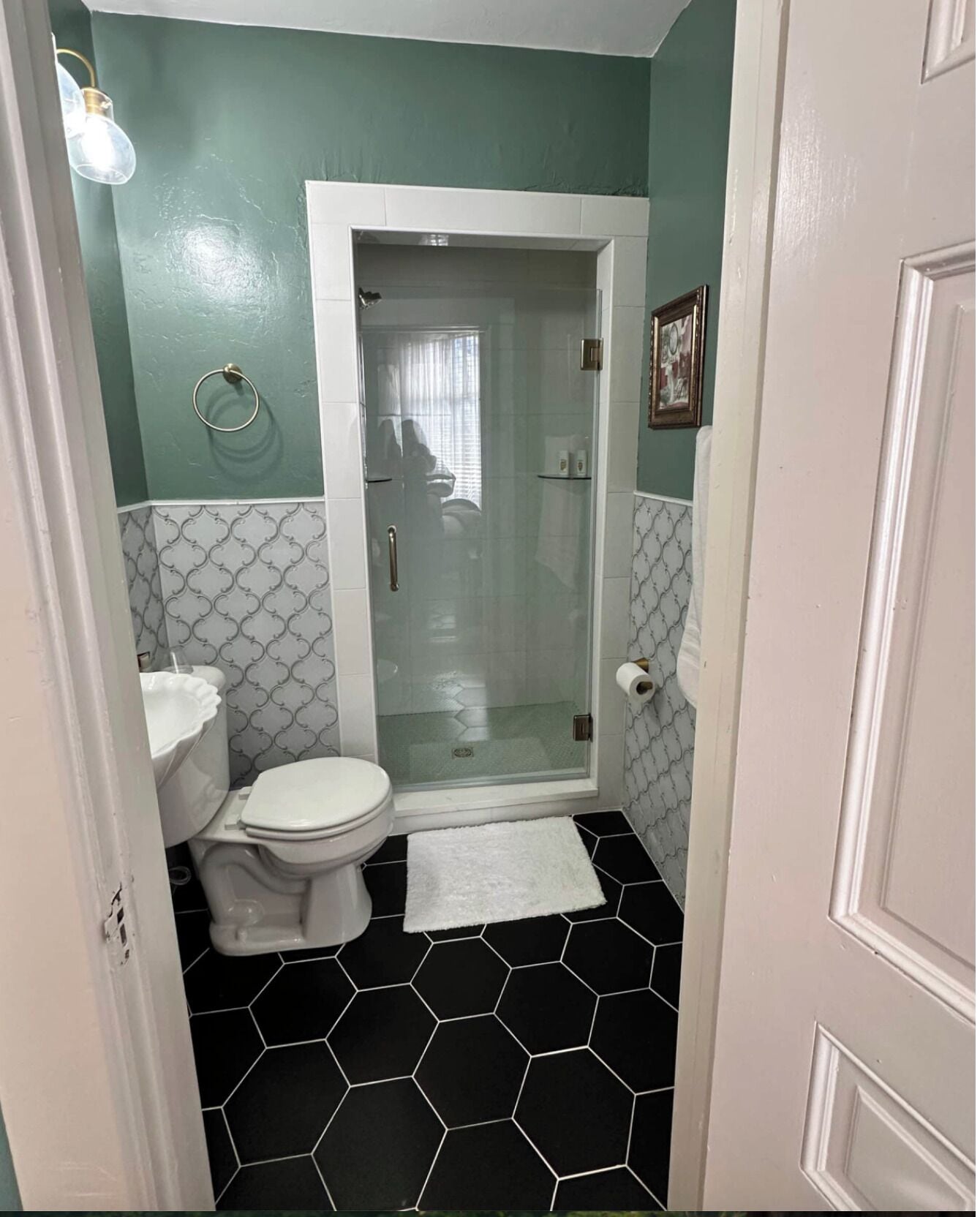 Ein Badezimmer mit Toilette, einer Duschkabine mit Glastür und einem weißen Waschbecken.