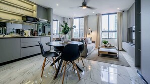 A modern kitchen with a dining area, a sofa, and a coffee table.