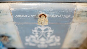 A close-up of a light fixture on a wall with a decorative pattern.