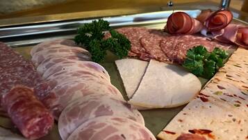 A variety of meats including sausages, salami, and sliced ham arranged on a tray.