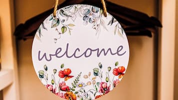 Un letrero circular de bienvenida con motivos florales y la palabra 'welcome' en el centro.