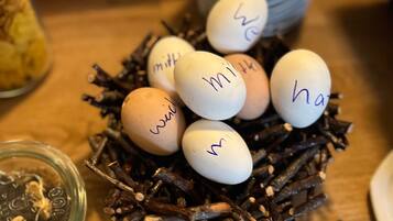 A nest of eggs with handwritten labels, a jar of what appears to be a food item, and a small sign with text.