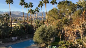 A swimming pool surrounded by palm trees and a mountainous landscape in the background. - Charming 2-bedroom villa with terrace best view of mountain in Palm Springs area (Cathedral City)