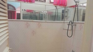 A small, tiled shower room with a window and pink curtains. - Villa Nickerie (Nieuw Nickerie)