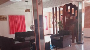 A spacious lobby with a tiled floor, a brick accent wall, and a red curtain. - Villa Nickerie (Nieuw Nickerie)