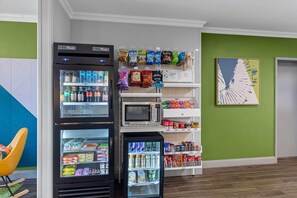 Un espace équipé d’un distributeur automatique de collations et de boissons, d’un four à micro-ondes et d’un réfrigérateur.