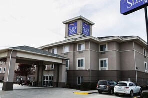 A Sleep Inn hotel with a covered entrance, multiple windows, and a signboard. - Spark by Hilton Killeen (Killeen)