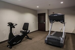 A room with a stationary bike, a treadmill, and a door. - Spark by Hilton Killeen (Killeen)