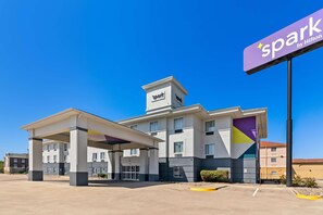 A hotel with a 'spark by Hilton' sign, a covered parking area, and a multi-story building with a modern design. - Spark by Hilton Killeen (Killeen)