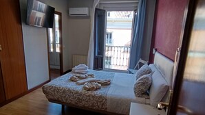 A bedroom with a bed, a bedside table, a TV, and a window with curtains. - Hostal New Life Madrid  (Madrid)