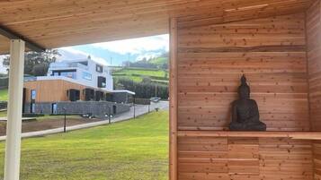 En trækonstruktion med en statue af en siddende figur, sandsynligvis Buddha, i en meditativ stilling.