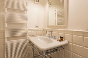A bathroom with a white sink, chrome faucet, and towel rack. - Rinascimento Privato by MMega (Florence)