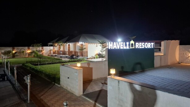 Een goed verlichte hotelingang met een bord waarop staat: HAVELI RESORT.