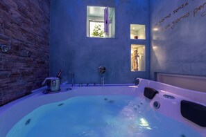 Une salle de bain moderne avec une grande baignoire, une fenêtre et un mur orné d’une citation.