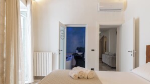 A hotel room with a bed, a bathroom visible through an open door, and a radiator.