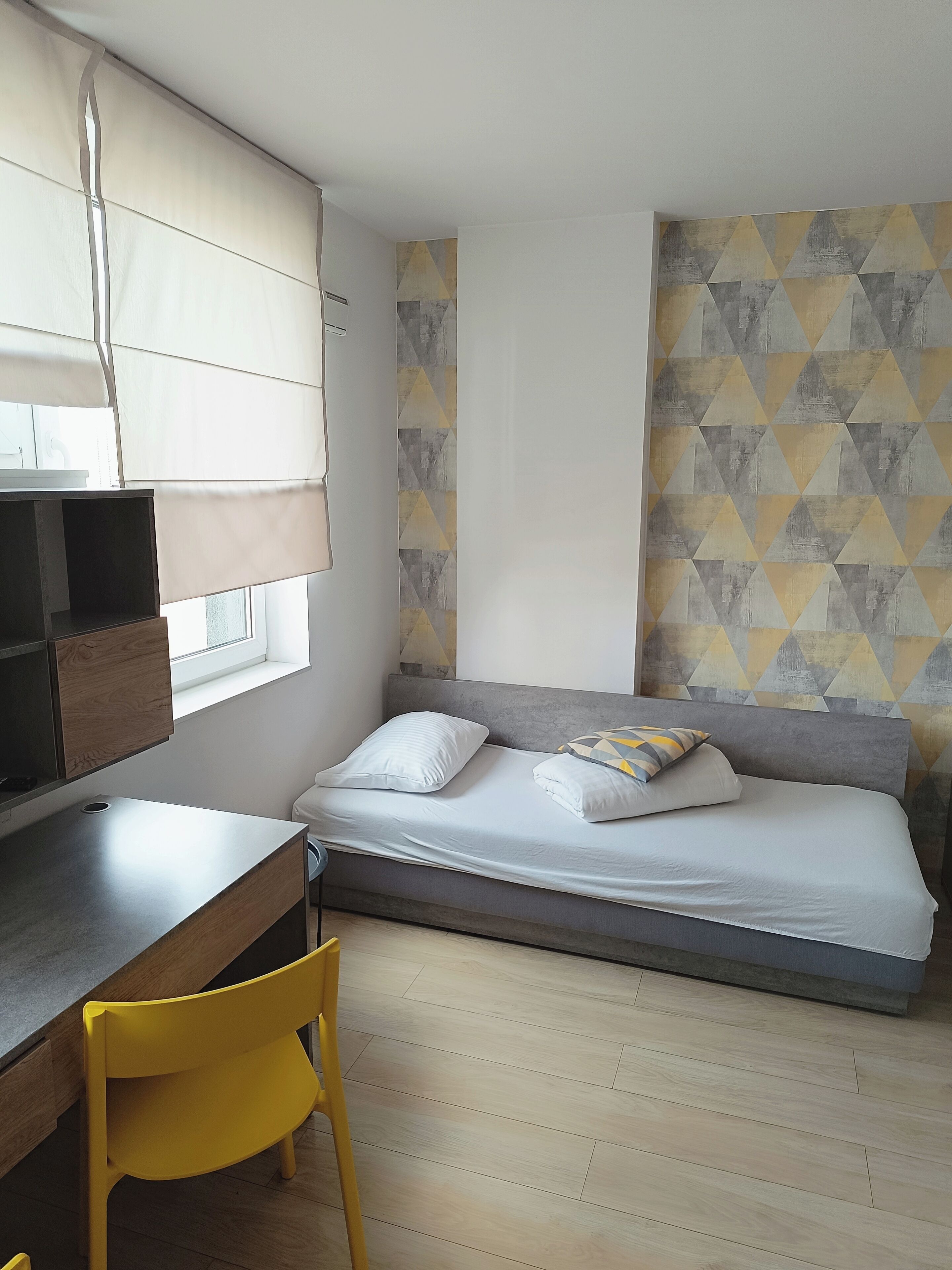 Ein Schlafzimmer mit einem Bett, einem Schreibtisch und einem Stuhl.