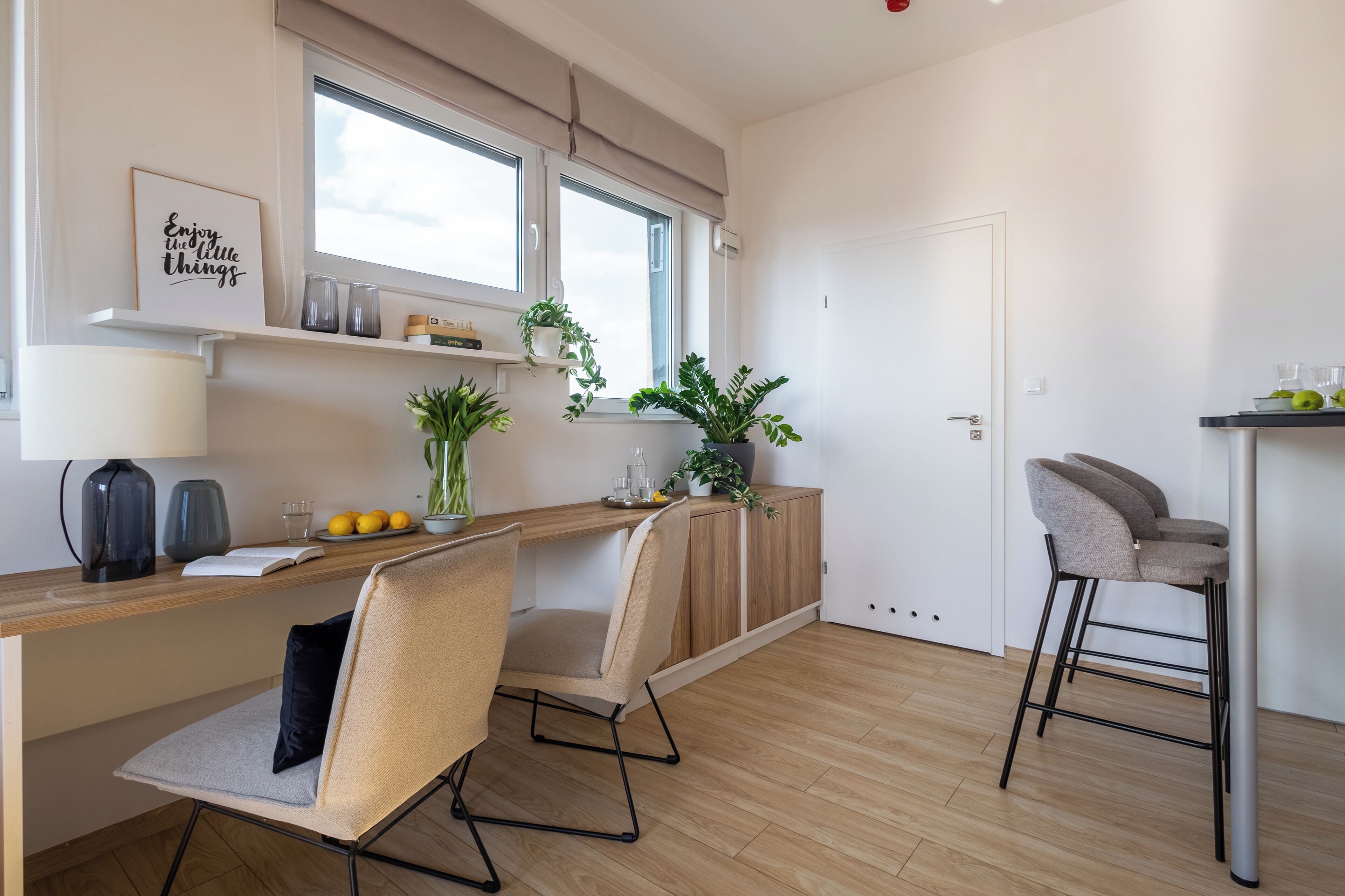 A modern kitchen with a wooden countertop, a built-in bench, and a bar stool.