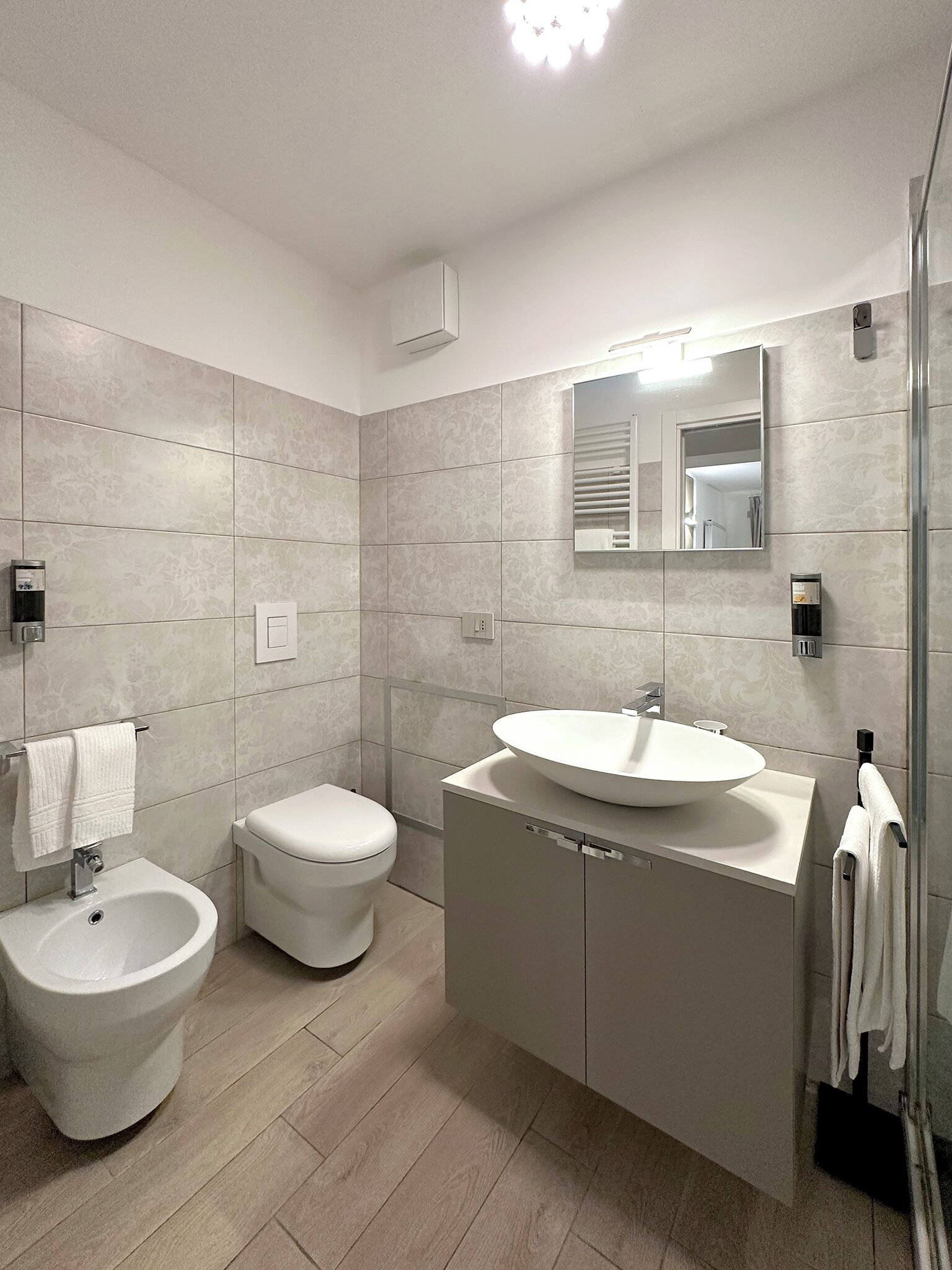 Un baño moderno con bidé, inodoro y lavamanos.