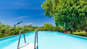 A swimming pool with metal ladders, surrounded by greenery and trees. - Apartment 'Santina' with Mountain View, Wi-Fi and Air Conditioning (Girasole)