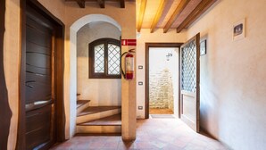 A hallway with a fire extinguisher, a staircase, and a door with a number sign. - Apartment 'Santina' with Mountain View, Wi-Fi and Air Conditioning (Girasole)
