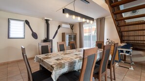 Un área de comedor con una mesa cubierta por un mantel estampado, rodeada de sillas de madera con asientos acolchados.