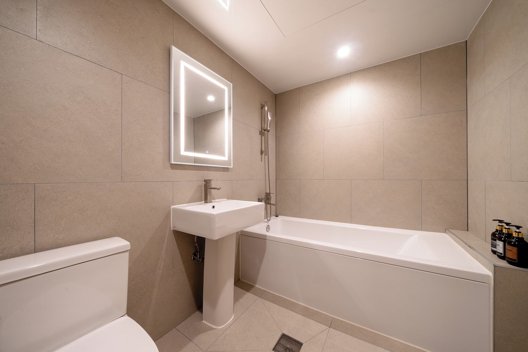 Ein modernes Badezimmer mit Badewanne, Waschbecken und Toilette.