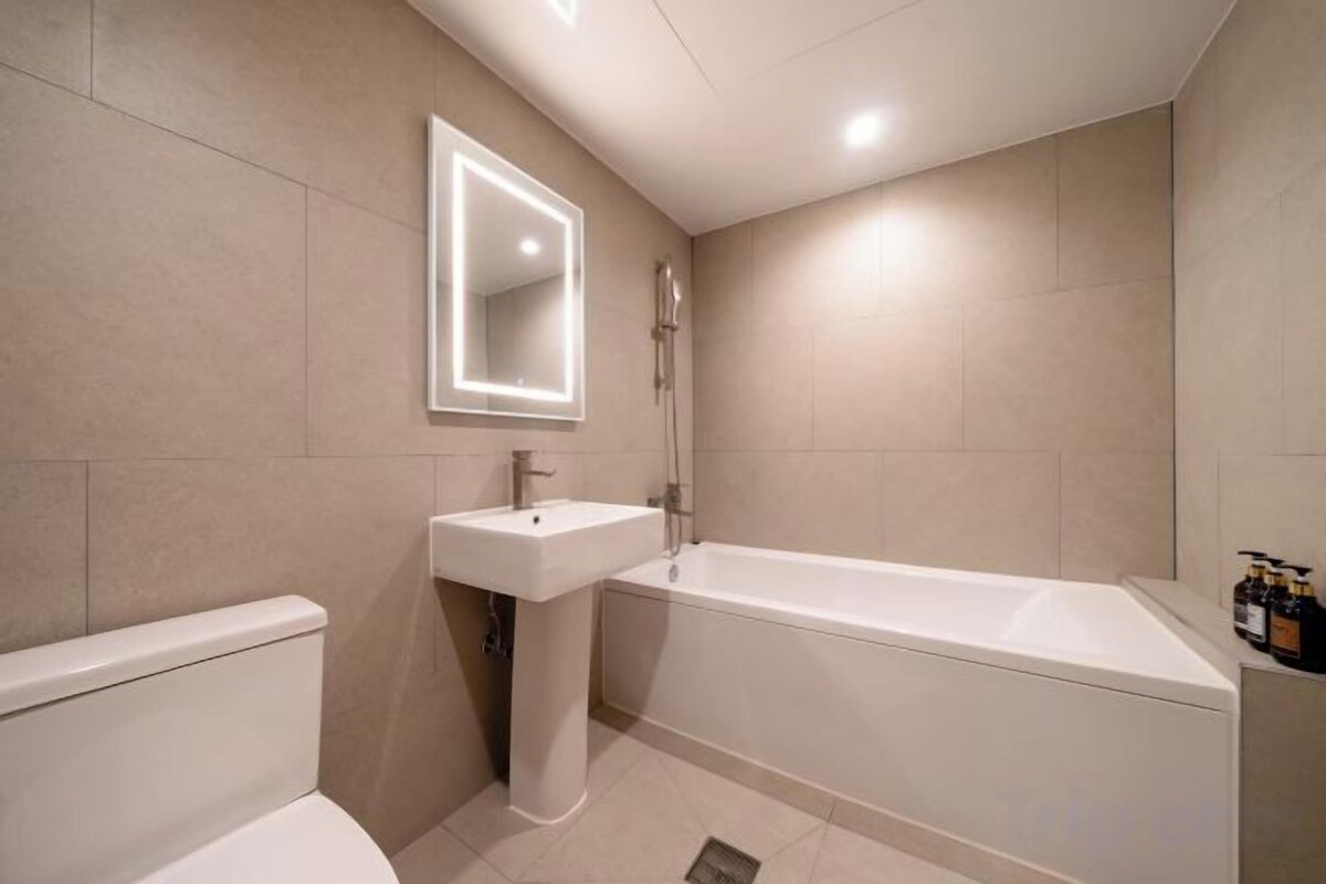 A modern bathroom with a toilet, sink, and bathtub.
