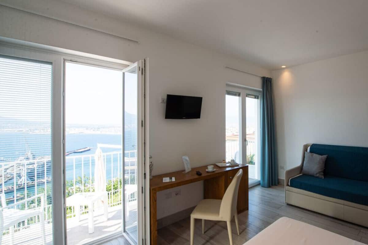 Una habitación moderna con escritorio, sofá y televisor.
